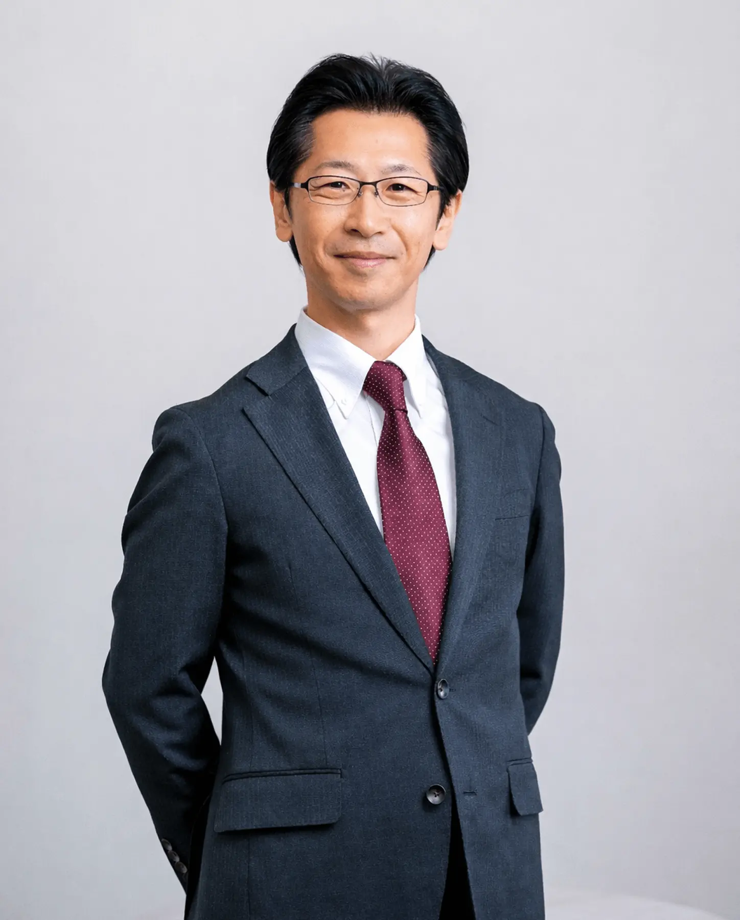 スーツ姿の男性が落ち着いた表情で立っているポートレート写真。株式会社ジャングル不動産 代表取締役・森田 良一の紹介用イメージ。